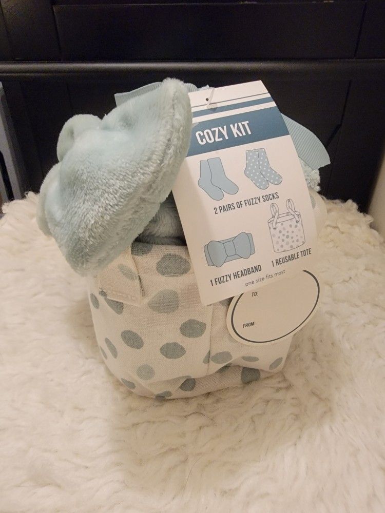 Cozy Kit gift set containing two pairs of fuzzy socks, one fuzzy headband, and a reusable tote.