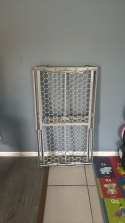 plastic, pressure-mounted safety gate (baby gate or pet gate).