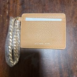 Michael Kors Jet Set Travel leather card holder featuring a gold-tone wrist chain. 
