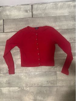 The Ambiance Red Button Front Knit Cardigan Sweater is a stylish and cozy addition to any woman's wardrobe. This solid red sweater features a round ne