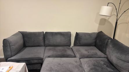 Dark gray sectional couch in soft velvet fabric. Spacious, comfortable, and modern look. Neutral color fits any room.