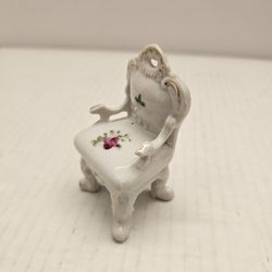 vintage porcelain dollhouse chair, likely made in Japan, featuring hand-painted floral details and gold accents. 