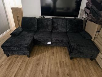 New 4-piece U-shaped sectional in black velvet with washable covers.