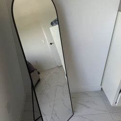 modern black arched full-length mirror with a stand