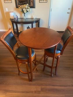 3-piece pub-height dining set consisting of:  * 1 round wood pub table * 2 padded swivel bar-height chairs