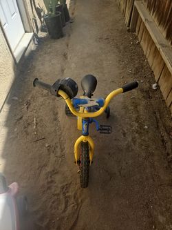 a blue and yellow 12-inch Magna Hot Rod children's bike