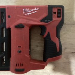 The tool shown is the Milwaukee M12 3/8" Crown Stapler, model number 2447-20