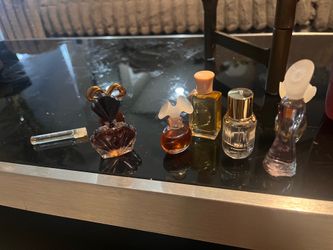 Assorted collection of vintage miniature perfume bottles. This set includes glass bottles in various shapes and sizes, containing different shades of 