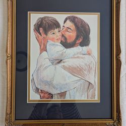 JESUS HOLDING LITTLE BOY IN NAVY BLUE AND GOLD MATTED FRAME UNDER GLASS
