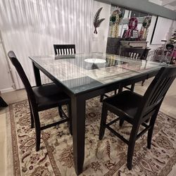 Tall dining room table with glass top and four (4) chairs
