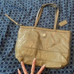Green coach purse with white coach stitching for a design on the outside with silver hardware