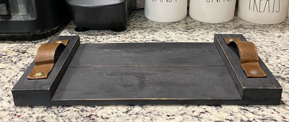 Solid wooden serving tray or decorative riser resting on a kitchen countertop