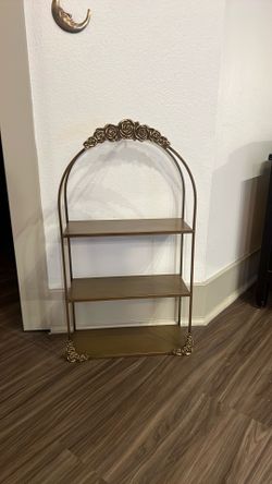 vintage-looking gold wall shelf with roses