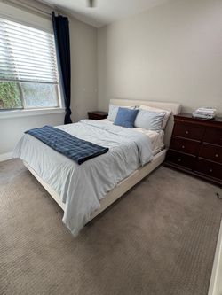 Upholstered queen bed with mattress and mattress topper