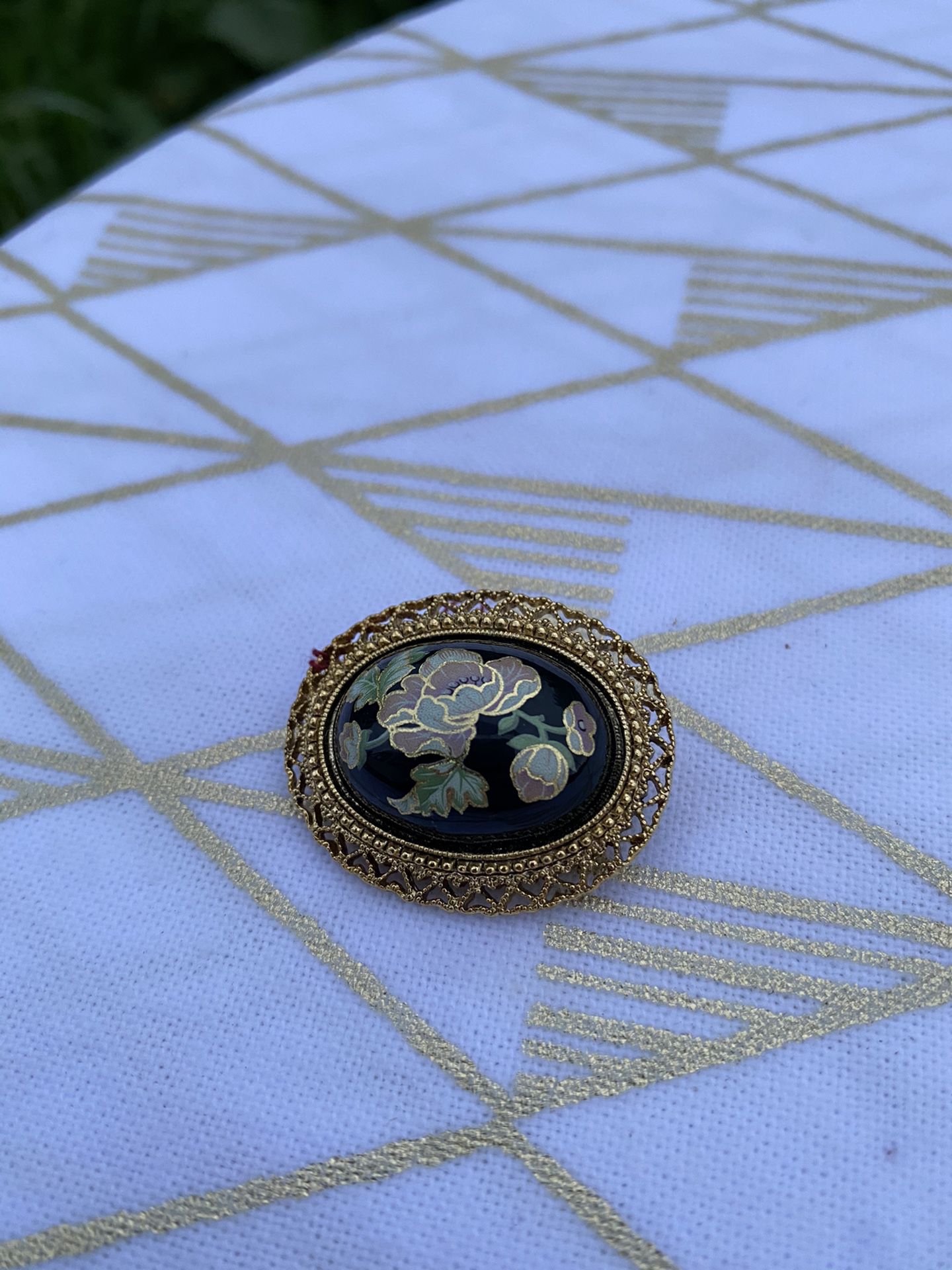 Vintage Brooch Pin with Floral Detail and Filigree Border on Black Background