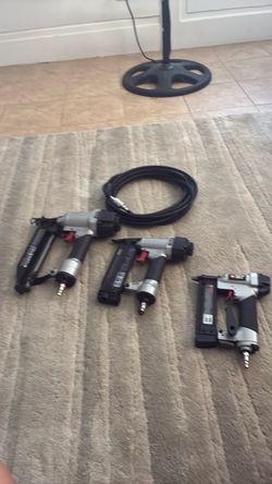 Three nail guns with air hose Three nail guns with air hose