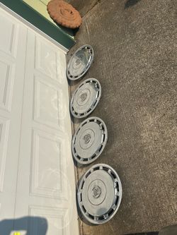 Four Cadillac hubcaps in decent condition. I cleaned them up some, but they can be shined up even better. All metal. I’m guessing they’re from the 70s