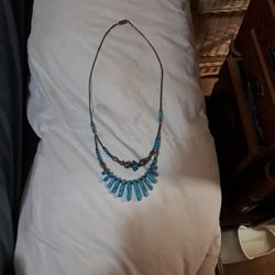Necklace comprised of two distinct strands, giving it a layered look.
Turquoise stones: The lower strand prominently features flat, rectangular-shaped