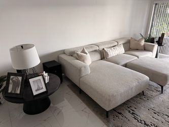 Large sofa with rug and two side tables.