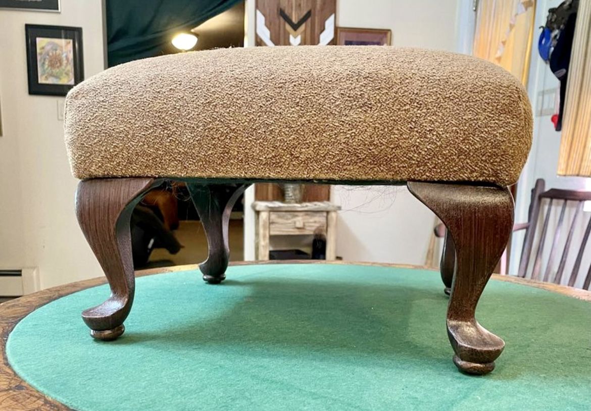Vintage upholstered footstool with wooden legs