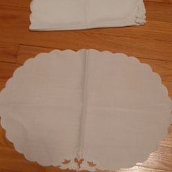 White scalloped table linens with decorative cutouts.