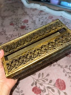 a vintage gold-tone metal filigree tissue box cover in the Hollywood Regency style.