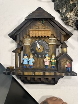 vintage German Black Forest chalet- style musical cuckoo clock featuring Hummel-style figurines.