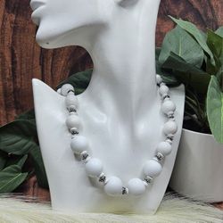 Chunky white beaded with silver accents long necklace is perfect for any occasion. The classic design features smooth white beads complemented by silv