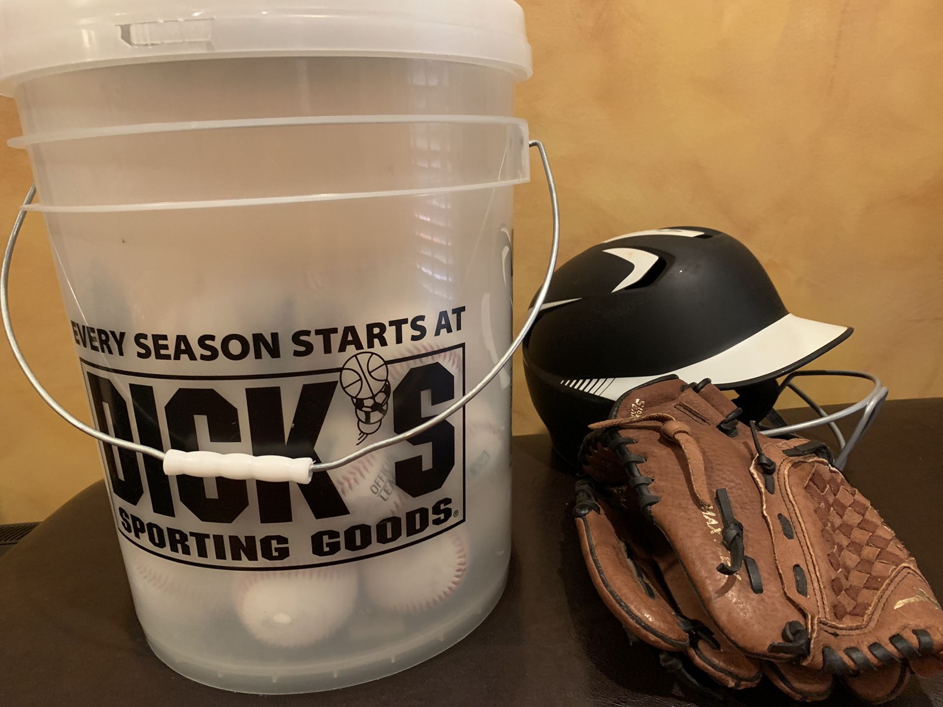 Baseball helmet ,glove and bucket of synthetic Baseballs