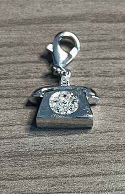Silver phone-shaped charm pendant with lobster clasp. Adds elegant flair to bags, keyrings, or accessories. Secure lobster clasp for easy attachment.