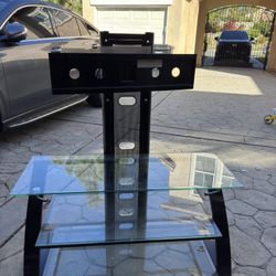 glass TV stand with a center mounting bracket (the black vertical rail with holes)