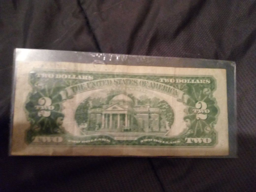 $2 Dollar Bill with red print on it.
