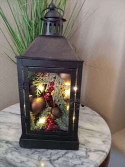 $15 Black Metal Lantern Filled with Artificial Pine with Bells And Lights. 
Batteries Not Included. 