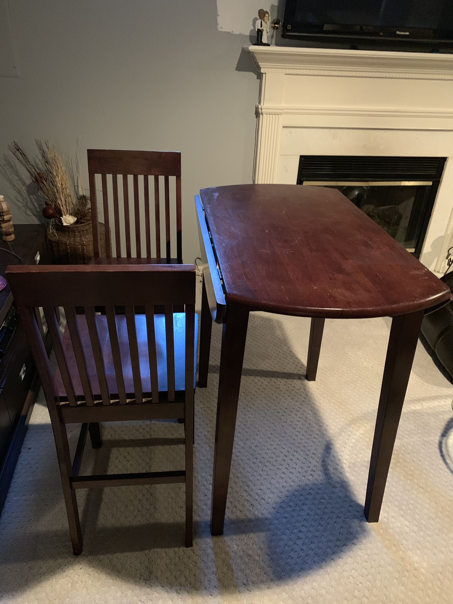 Beautiful brown wooden bar table with 2 matching chairs. Collapsible leafs make table round and 36”