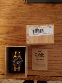 Women's gold watch with black trim.