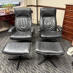 Two Black Leather Reclining Chairs With Matching Footstools