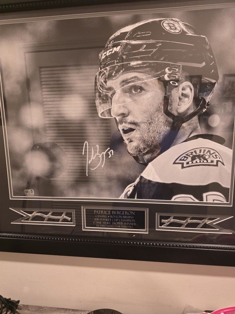 Autographed Patrice Bergeron picture with Game Used Net