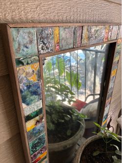 Mosaic tile-framed mirror.