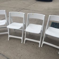Four White Folding Chairs