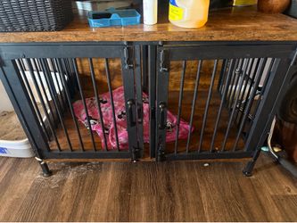 Metal dog crate with wooden top .