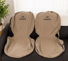 Tan fabric car seat covers for a Hyundai Sonata. This set includes two front seat covers with the Hyundai logo and Sonata text, along with rear seat a