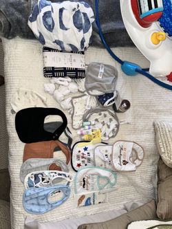 12 Baby Bibs,  Socks, 2-crib Sheets (new) 6 Washcloths, Teething Gel, Diaper Rash Cream (new) Thermometer. 