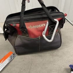 red and black Husky tool tote bag with random things inside