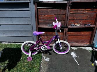 Girl Huffy bike with training wheels.