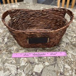 Brown woven basket with handles, approximately 12 inches long