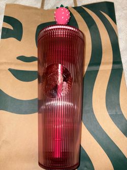 Pink plastic Starbucks cup with strawberry topper