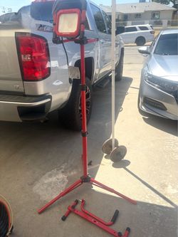 Craftsman portable LED work light mounted on an adjustable telescoping tripod stand with detachable base handles.