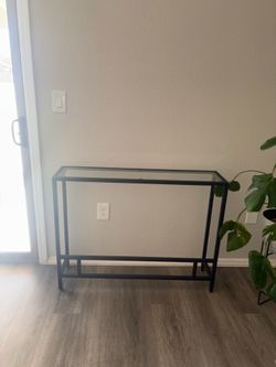 Small glass console with black metal frame