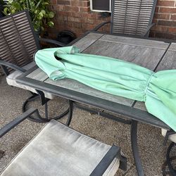 Outdoor table and chair,with umrella and cushions.