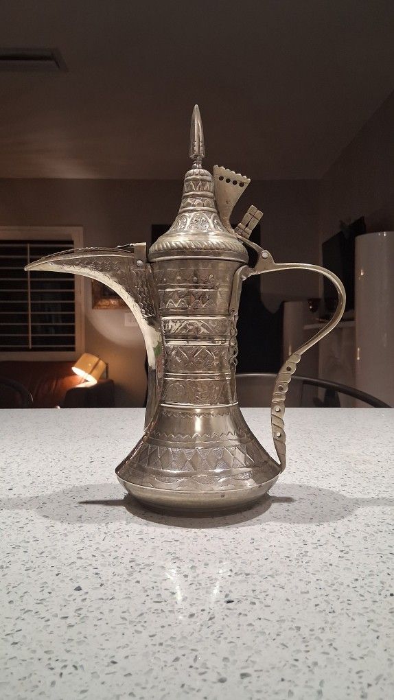 A Middle-Eastern white metal Dallah coffee pot
